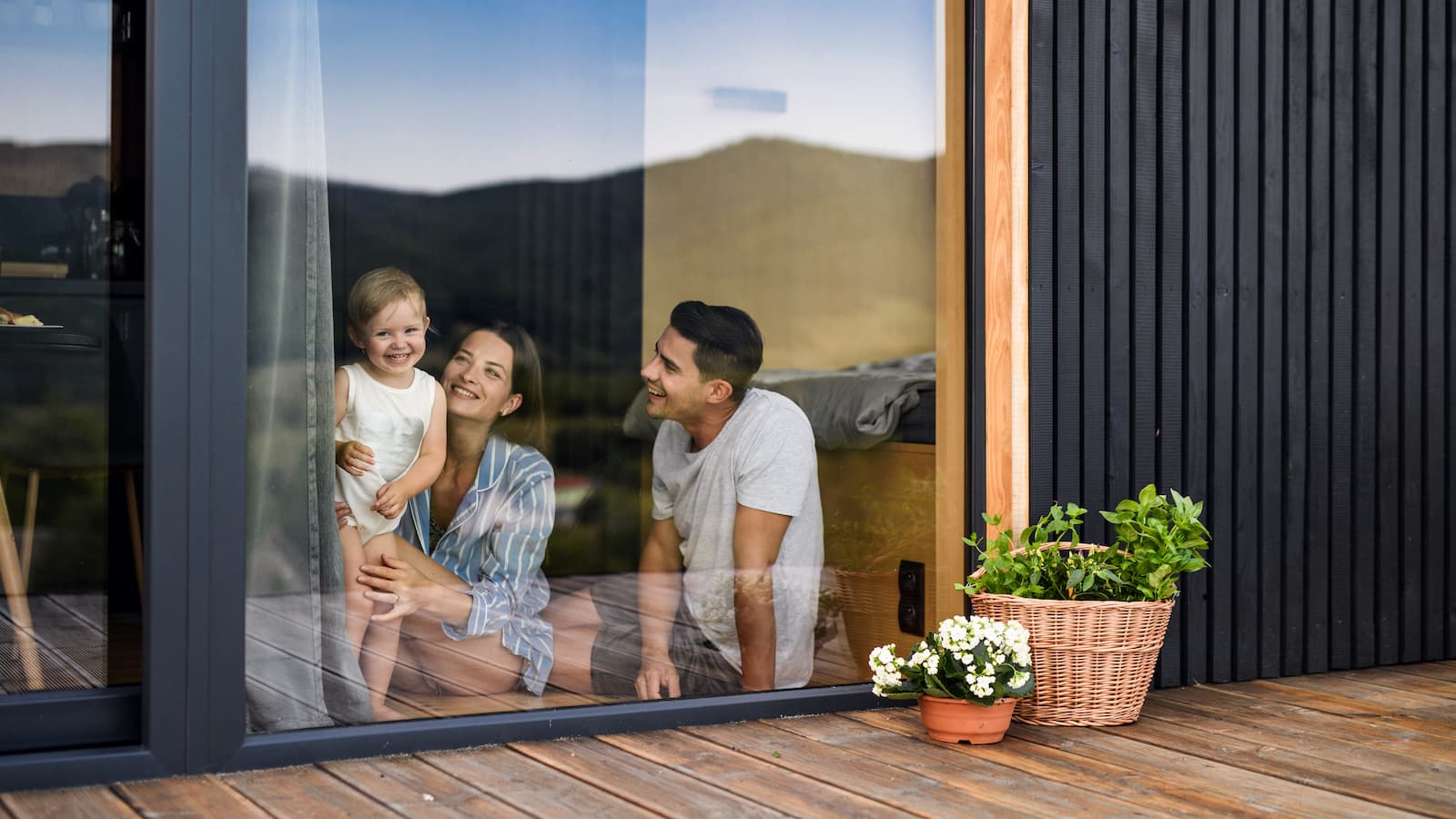 A family at home, seen through the window of their house.